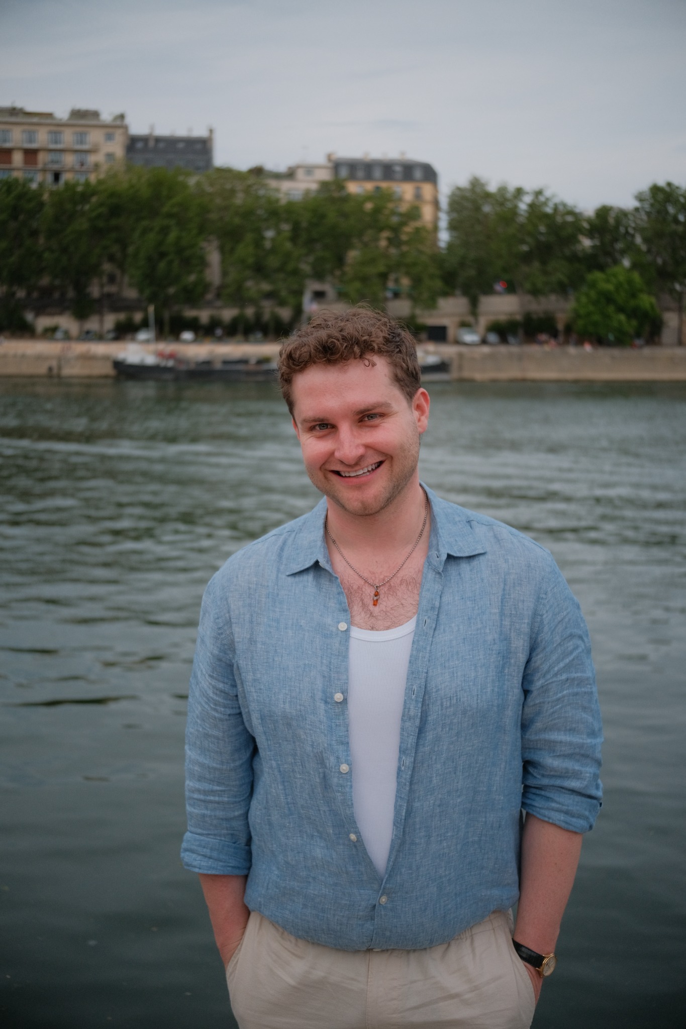 Max Klapow smiling by the water in a blue shirt